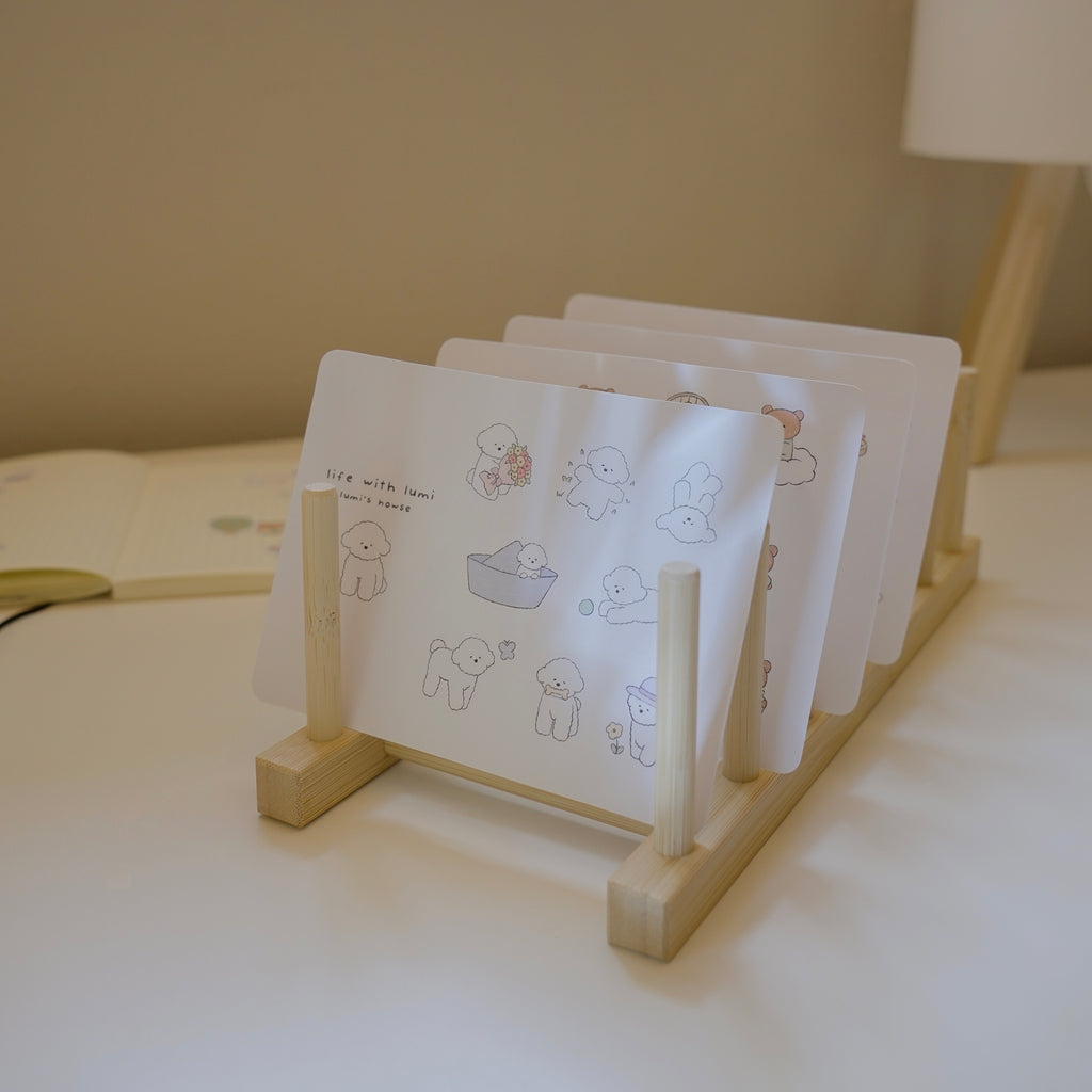 Set of sticker sheets with illustrations on a wooden stand on a light surface.
