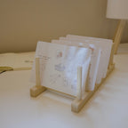 Set of sticker sheets with illustrations on a wooden stand on a light surface.