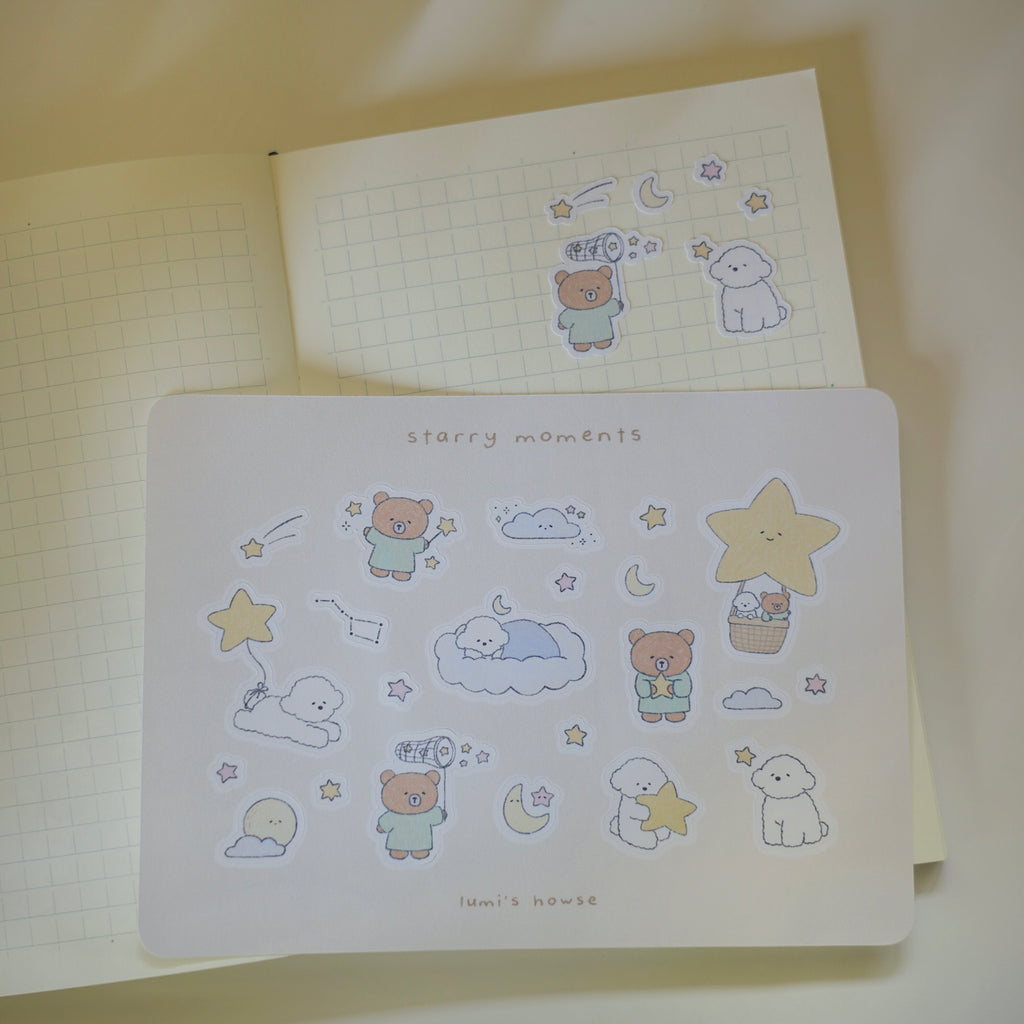 Sticker sheet over a notebook with cartoon characters and 'starry moments' text.