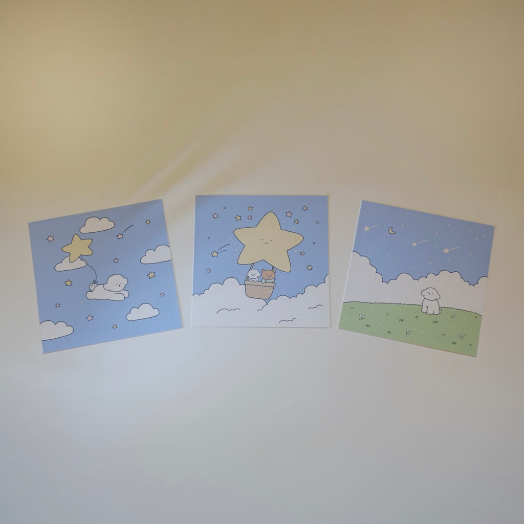 Three art prints with stars and dog designs on a white surface.
