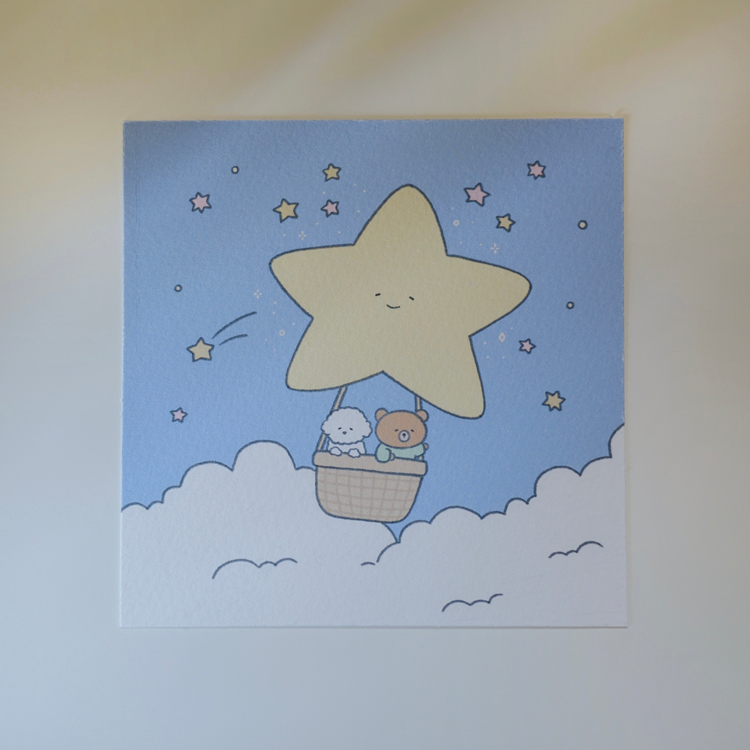 Cartoon star with a basket of a bear and a dog flying in the sky with clouds and stars.