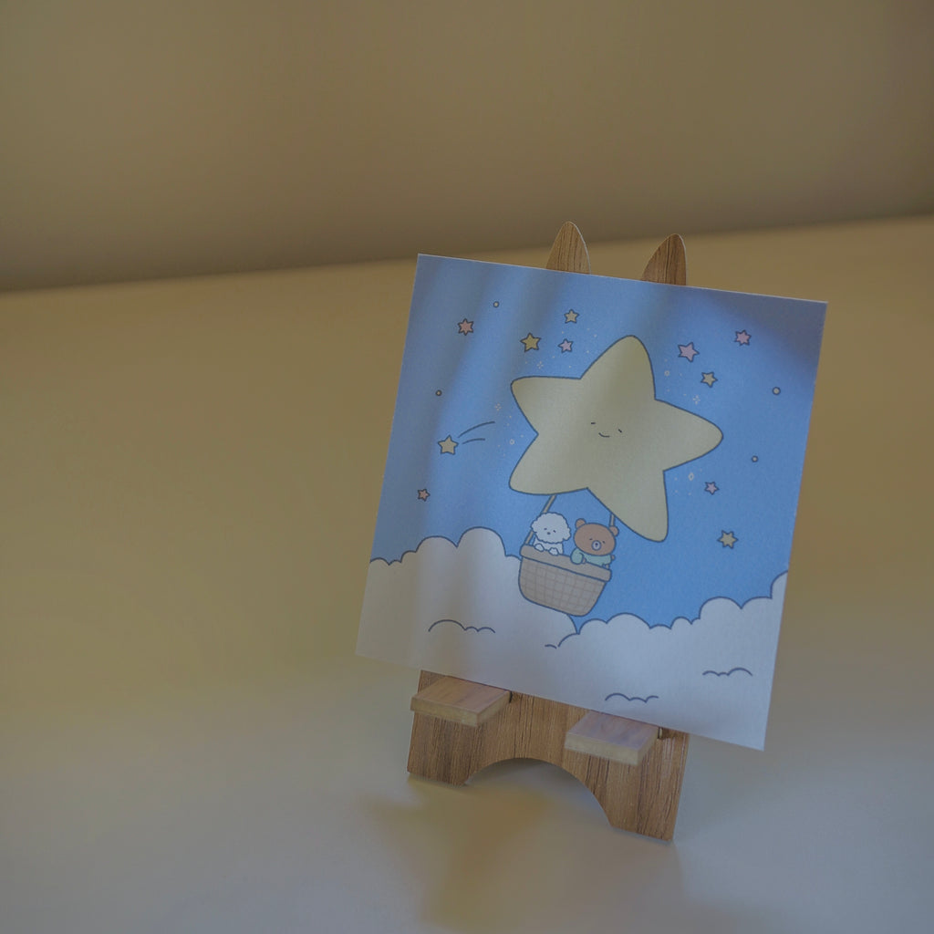 Art print with a star design on a wooden stand against a plain background.