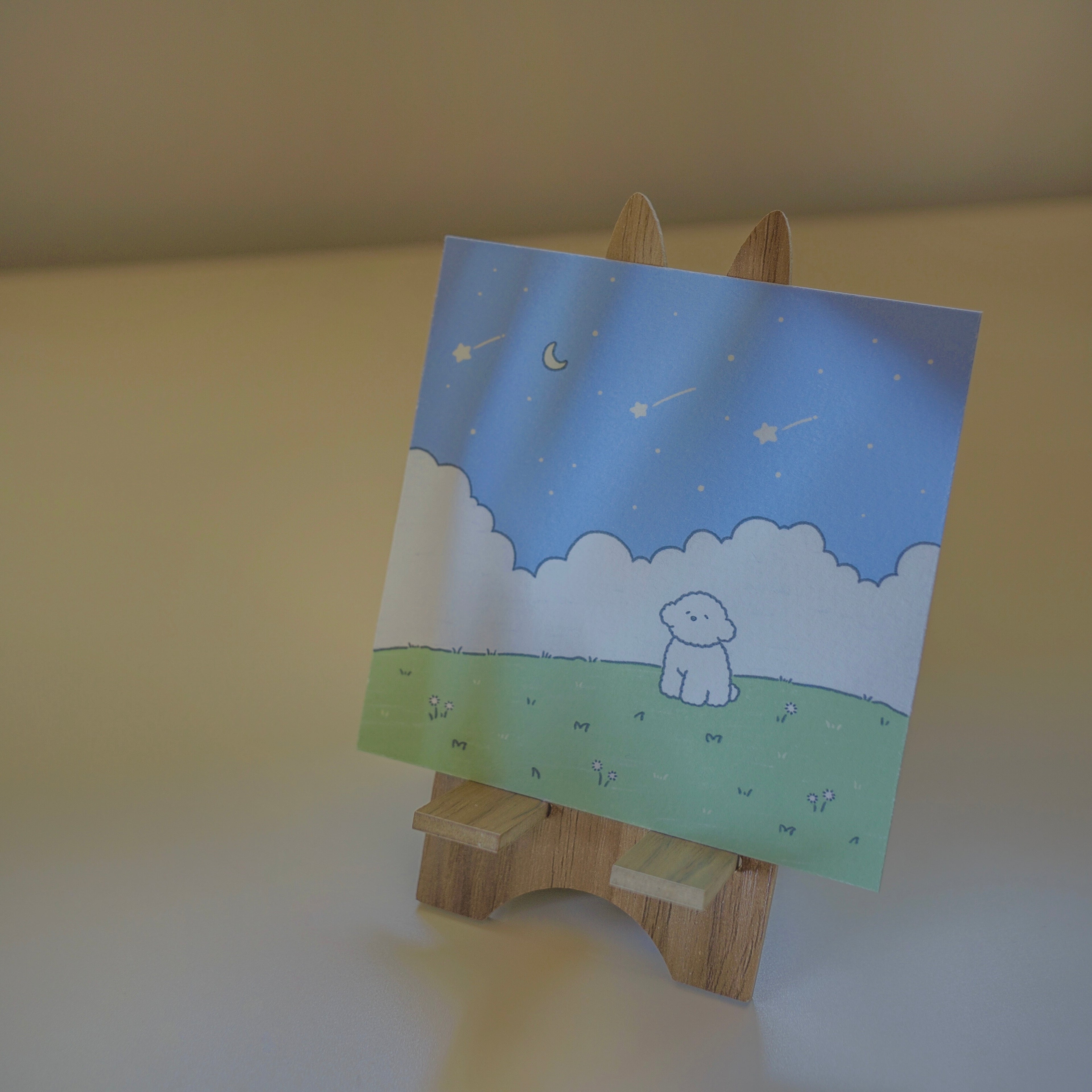 Art print with a dog illustration on a wooden stand against a beige background.