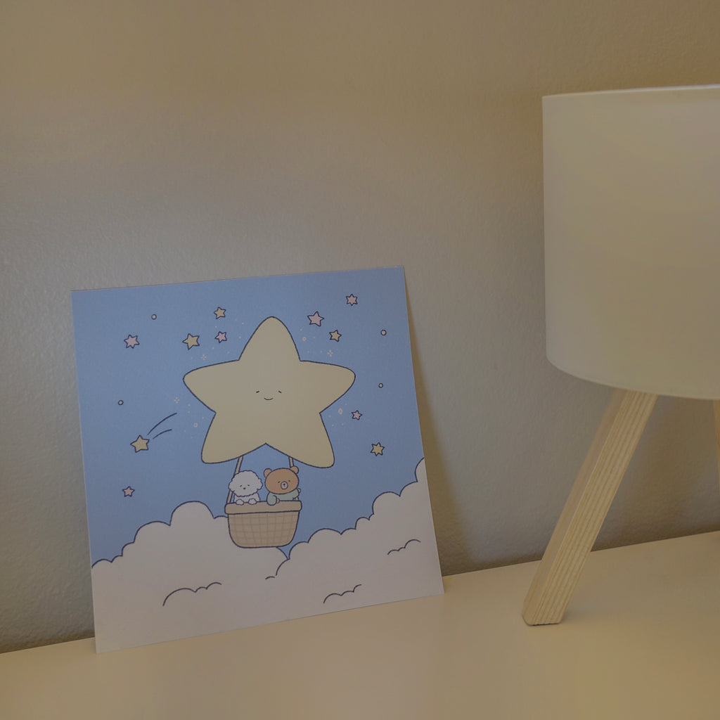 Art print with a star design on a table next to a lamp.