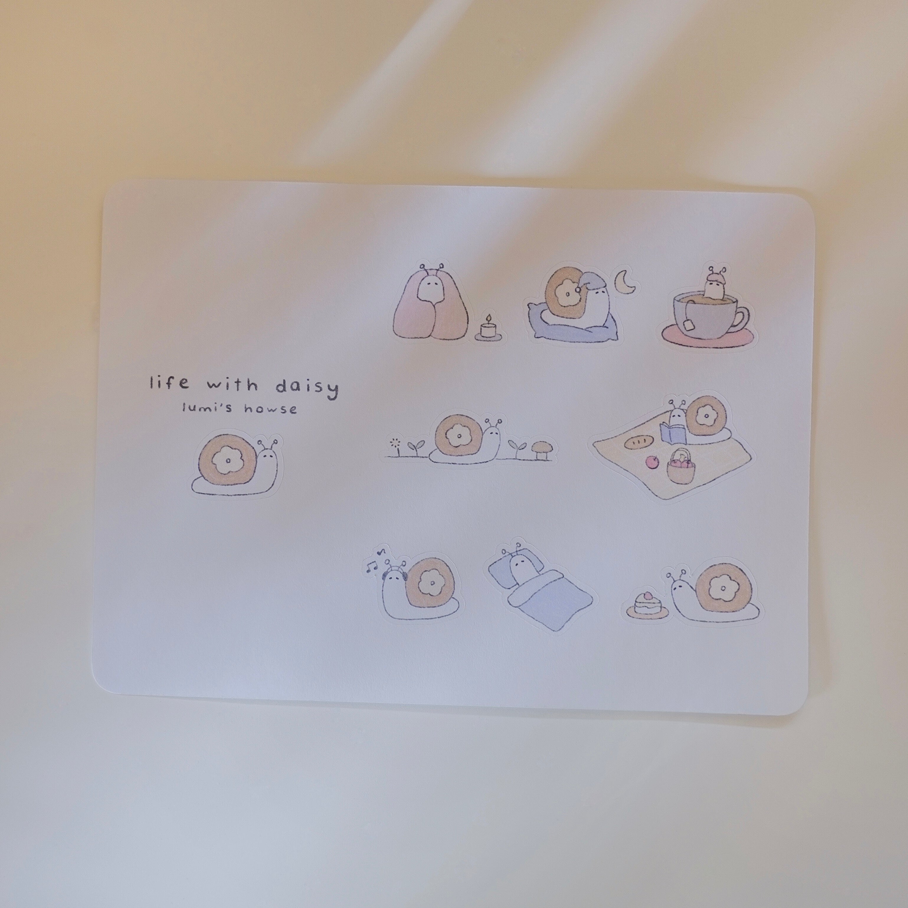 Sticker sheet with illustrations of a snail, featuring 'life with daisy' text.