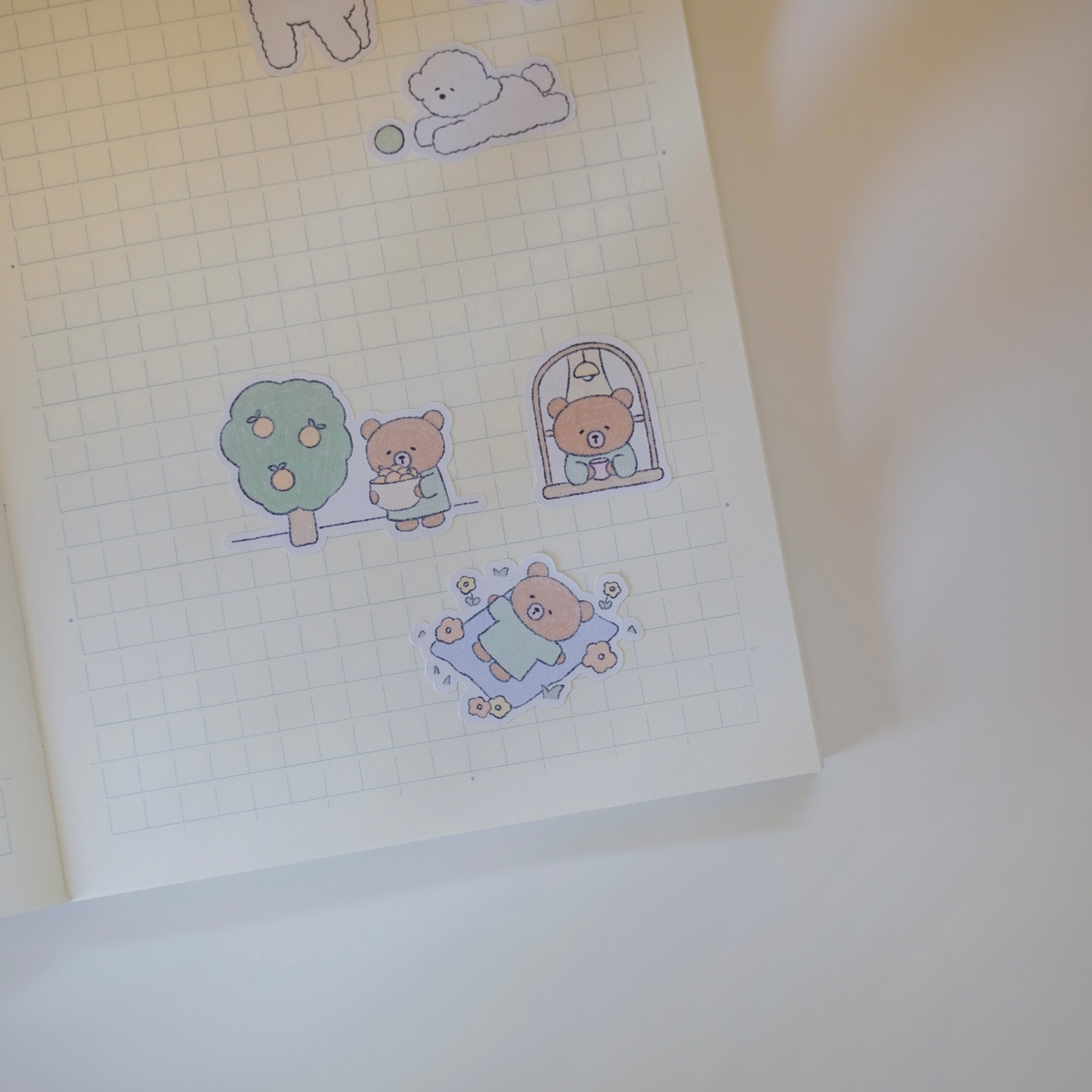Sticker sheet with cute bear illustrations on a grid notebook page.