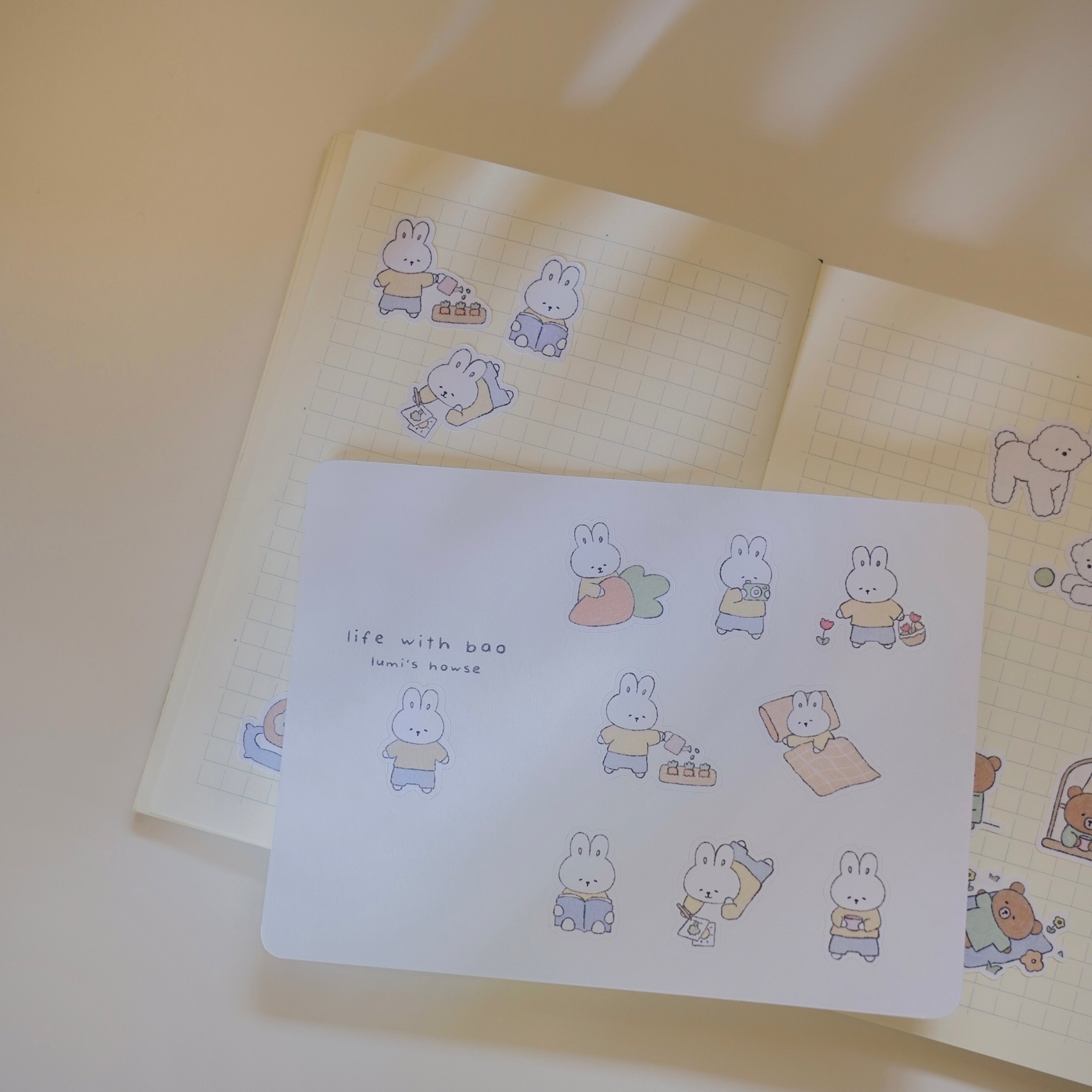 Notebook with cute bunny illustrations on a sticker sheet with a light background.